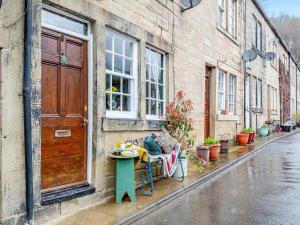 a table and a bench on the side of a building at Buttress Retreat in Hebden Bridge