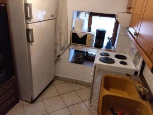 a small kitchen with a refrigerator and a stove at Akis Apartments in Mariaí