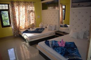 una camera da letto con due letti e uno specchio di Nice One Palace a Srinagar
