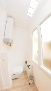 La salle de bains blanche est pourvue de toilettes et d'une fenêtre. dans l'établissement Superbe T2 calme & confortable - très bien situé!, à Ajaccio