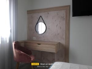 a room with a mirror and a pink chair at Summer Feelings in Skala Sotiros