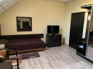 a bedroom with a bed and a tv and a mirror at ФИЕСТА in Hora