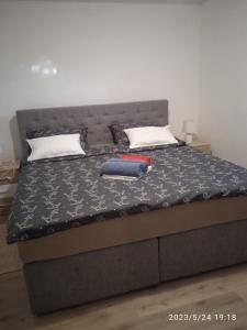 a bed with a black bedspread and a red book on it at Apartment Fortica in Senj