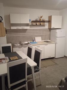 a kitchen with white cabinets and a table and chairs at Apartment Fortica in Senj