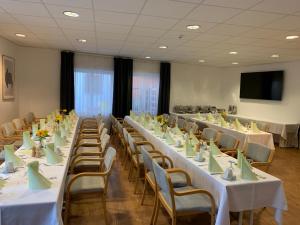 Sala de conferencias con mesas, sillas y TV en Hotel-Cafe Rathaus en Bad Abbach