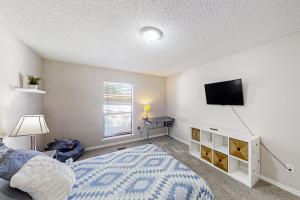 een slaapkamer met een bed en een flatscreen-tv bij Urban Oasis in Jacksonville