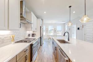 a kitchen with white cabinets and a sink and a stove at 4563 Summey Street in Charleston