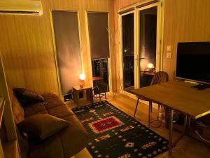 a living room with a couch and a table with a television at Cabane Jacomeli Genève in Collonges-sous-Salève