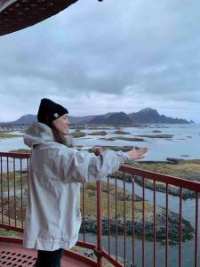 a man standing on a balcony looking at the water at House in the center of Andenes in Andenes