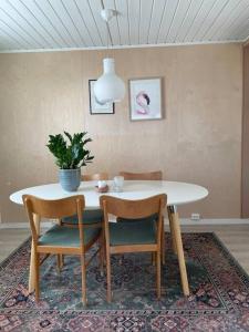 uma mesa de jantar com duas cadeiras e um vaso de plantas em House in the center of Andenes em Andenes