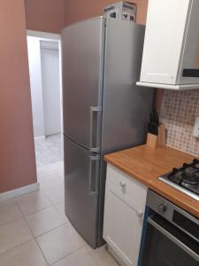 eine Küche mit einem Kühlschrank aus Edelstahl in der Unterkunft Conmere Square Apartment in Manchester