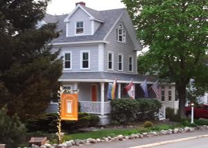 a white house with an orange sign in front of it at Bourne Bed and Breakfast in Ogunquit