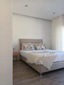 een slaapkamer met een groot bed met witte muren bij Vila dArte Alojamento local situado no Centro do País in Vila de Rei