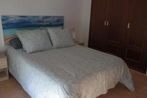 Un dormitorio con una cama con almohadas. en ALOJAMIENTO LUZ, en Facinas
