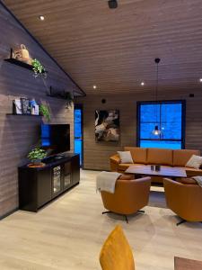 a living room with a couch and a table and chairs at Stryn Mountain Lodge in Stryn