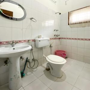 a bathroom with a toilet and a sink at Woods Luxury Homestay in Nainital