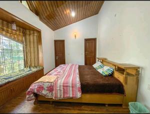 a bedroom with a bed in a room with a window at Woods Luxury Homestay in Nainital