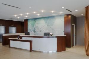 a lobby with a reception desk and a large wall at SpringHill Suites by Marriott Bloomington in Bloomington