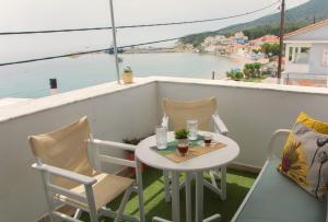een tafel en stoelen op een balkon met uitzicht op het water bij Ireon Holiday Home in Iraion