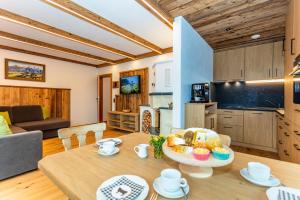 cocina y sala de estar con mesa y plato de comida en Biobauernhof Mittermoos, en Fieberbrunn