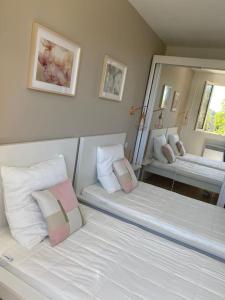 1 Schlafzimmer mit 2 Betten und einem großen Spiegel in der Unterkunft maison vacances 6 à 8 personnes parc du verdon in Sillans-la-Cascade