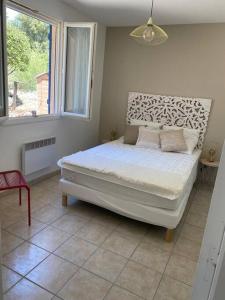 ein Schlafzimmer mit einem Bett in einem Zimmer mit einem Fenster in der Unterkunft maison vacances 6 à 8 personnes parc du verdon in Sillans-la-Cascade