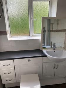 a bathroom with a sink and a window at LA Mansion in Wednesbury