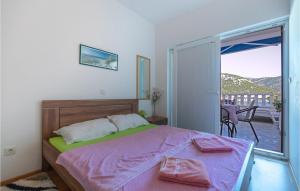 a bedroom with a bed with pink sheets and a balcony at Beautiful Apartment In Klek With House Sea View in Klek