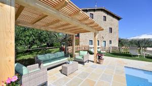 une terrasse avec une piscine et une pergola en bois dans l'établissement Poggio a Mandria, à Cavriglia