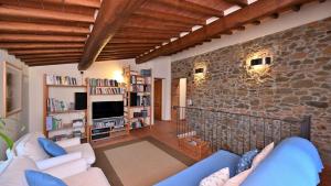 un salon avec un canapé et un mur en pierre dans l'établissement Poggio a Mandria, à Cavriglia