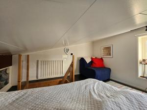 1 dormitorio con 1 cama y 1 sofá azul en Borrebjär, en Varberg