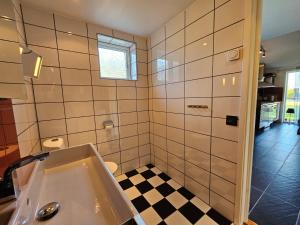 a bathroom with a sink and a black and white checkered floor at Borrebjär in Varberg
