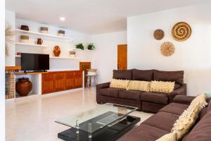 - un salon avec un canapé et une télévision dans l'établissement Villa Jazmin, à Sant Llorenç de Balafia