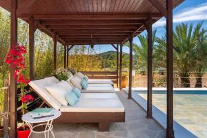 een houten prieel met een bank op een patio bij Villa Jazmin in Sant Llorenç de Balafia