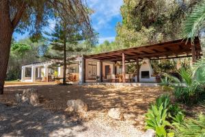 una casa con una pérgola de madera en un patio en Villa Jazmin, en Sant Llorenç de Balàfia