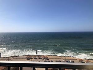 un balcón con vistas a la playa y al océano. en شقة فخمة فيوالبحر Luxury Panorama Sea View en Alexandría