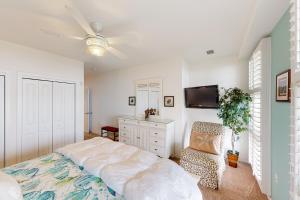 1 dormitorio con 1 cama y TV de pantalla plana en The Sanctuary - Sunset Thrille Penthouse B431, en Virginia Beach