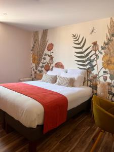 Logis Hôtel de france في La Côte-Saint-André: غرفة نوم مع سرير مع زهور على الحائط