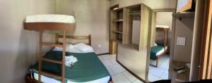 Cette petite chambre comprend 2 lits superposés et un miroir. dans l'établissement Pousada da Praia Imbé, à Imbé