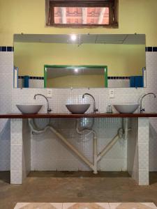 a bathroom with two sinks and a mirror at Hotel Fazenda Boa Esperança in Delfim Moreira