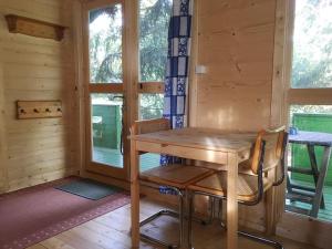 a wooden table and chairs in a room with windows at U M&M in Łagów