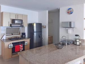 a kitchen with a stainless steel refrigerator and a counter top at Reserva del Mar - Club de Playa, vista al Mar in Gaira