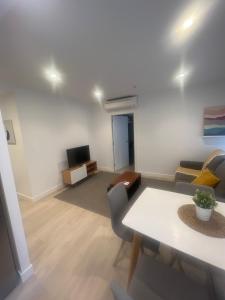 sala de estar con mesa y sofá en CONCHEIROS 5 APARTAMENTOS TURISTICOS, en Santiago de Compostela