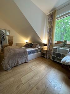 a bedroom with a bed and a large window at Comfort Zone Ostroda BOHO SCANDI in Ostróda