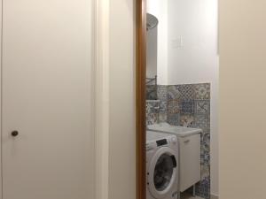 a bathroom with a washing machine and a washer at La Capinera Holidays in Santa Flavia