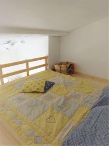 ein Bett mit einer Decke in einem Schlafzimmer in der Unterkunft Beautiful house near the beach, 4 bedrooms in Bidart
