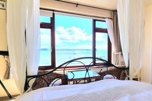 a bedroom with a bed and a view of the ocean at The Old Admiralty Boathouse - at Cawsand Beach in Cawsand
