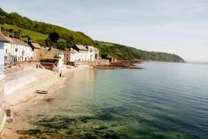a view of a beach with houses and the water at The Old Admiralty Boathouse - at Cawsand Beach in Cawsand