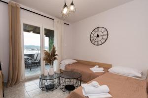 ein Schlafzimmer mit 2 Betten und einer Uhr an der Wand in der Unterkunft George's sea view apartment in Toroni