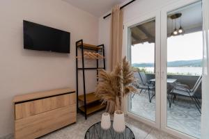 ein Wohnzimmer mit einem TV und einem Tisch mit Stühlen in der Unterkunft George's sea view apartment in Toroni
